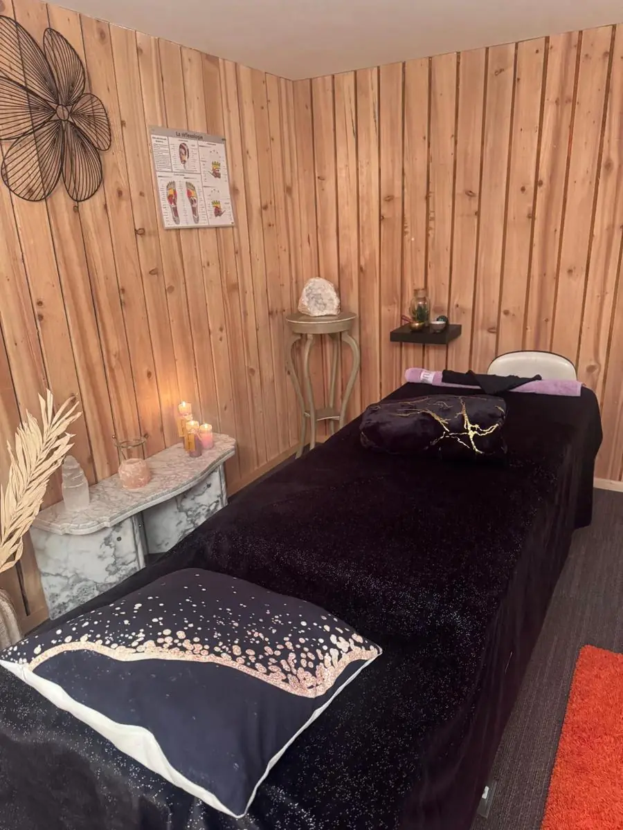 La table de massage préparée, coussin et plaid noirs et dorés